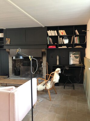 A room with a fireplace, a bookshelf, a chair, and a desk. - COTTAGE IN A TYPICAL FISHERMEN'S VILLAGE 5 mn from the beach (Blainville-sur-Mer)