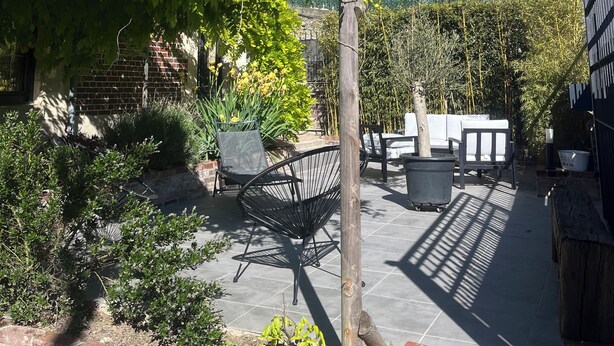 A courtyard with a pergola, seating area, and a brick wall. - Charming house (Béthisy-Saint-Martin)