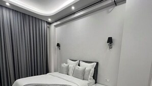 Ein modernes Schlafzimmer mit einem Bett, Nachttischen und einer Wandleuchte.