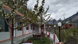 A building with a patio area, outdoor seating, and a view of mountains.