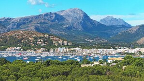 A coastal town with a marina, buildings, and mountains in the background. - Stylish Retreat, A/C, Private Pool - Walking Distance (15mins) to Port de Pollenca & Beach! (Pollença)
