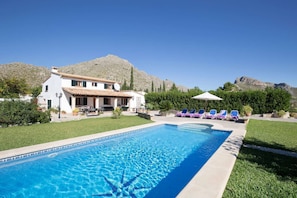 A pool with a mountain backdrop, a white building with a tiled roof, and lounge chairs. - Stylish Retreat, A/C, Private Pool - Walking Distance (15mins) to Port de Pollenca & Beach! (Pollença)