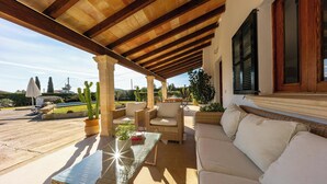 An outdoor patio with a glass table, wicker furniture, and a white sofa. - Stylish Retreat, A/C, Private Pool - Walking Distance (15mins) to Port de Pollenca & Beach! (Pollença)