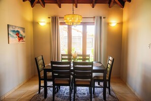 A dining area with a table, chairs, a chandelier, and a painting on the wall. -     Wayaca Oasis Retreat-Private Pool + 4BR + Prime Location in Aruba (Oranjestad)