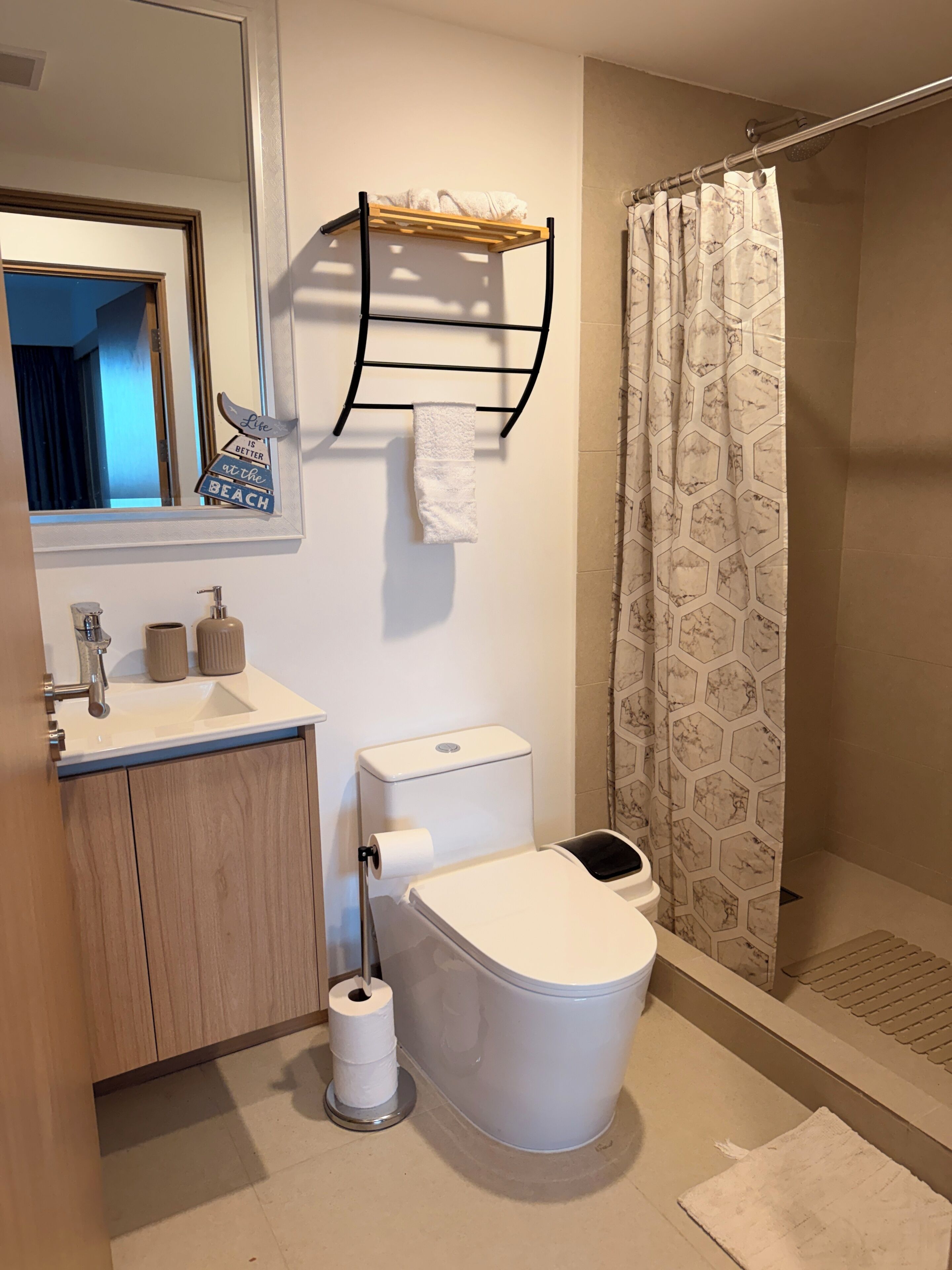 Une salle de bain équipée de toilettes, d’un lavabo et d’un rideau de douche.