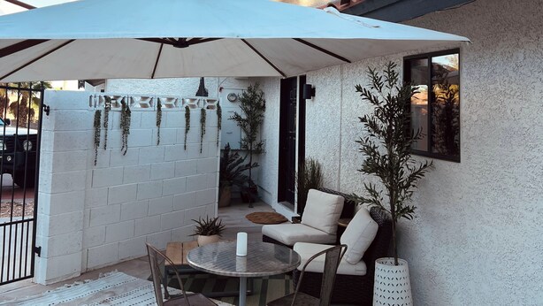 A patio with a table and chairs, a white wall, and a red-tiled roof. - Spacious 2BR Guest House - Perfect for Remote Work, Family and Pet-Friendly (Las Vegas)