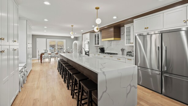 A modern kitchen with a central island, stainless steel appliances, and a long dining area. - Grand 8BR Estate w/ Game Room (Morristown)