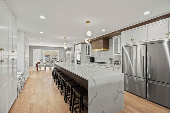 Una cocina moderna con una isla central, electrodomésticos de acero inoxidable y una amplia zona de comedor.