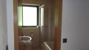 Een badkamer met toilet, wastafel en douche.
