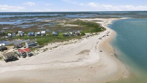 Oversigtsbillede af et kystområde med strand, bygninger og et vandareal.