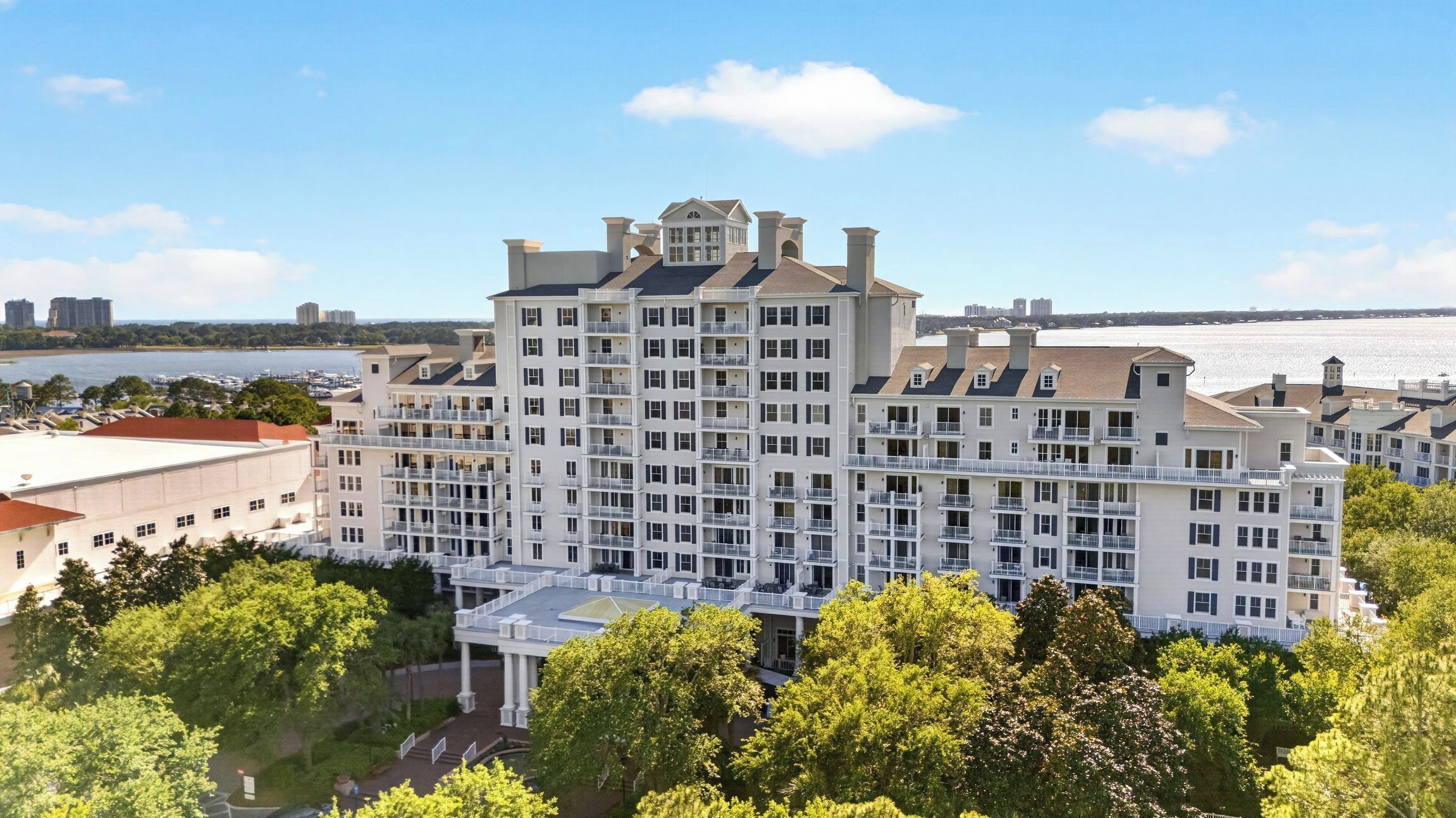 Un hôtel à plusieurs étages doté d’une cour intérieure, de balcons et offrant une vue sur l’eau.