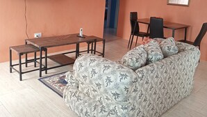Un soggiorno con divano, televisore, tavolo da pranzo e sedie.
