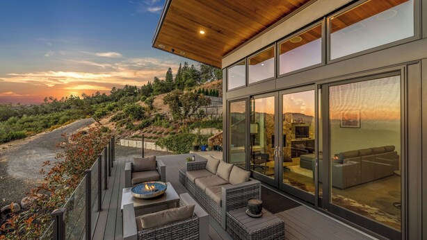 A modern outdoor living area with a fire pit, seating, and a view of the landscape. - Trinity Vista by Avantstay Private Dual-zone Spa + Fire Pit + Outdoor Dining + Views Sonoma Wine Country (Glen Ellen)