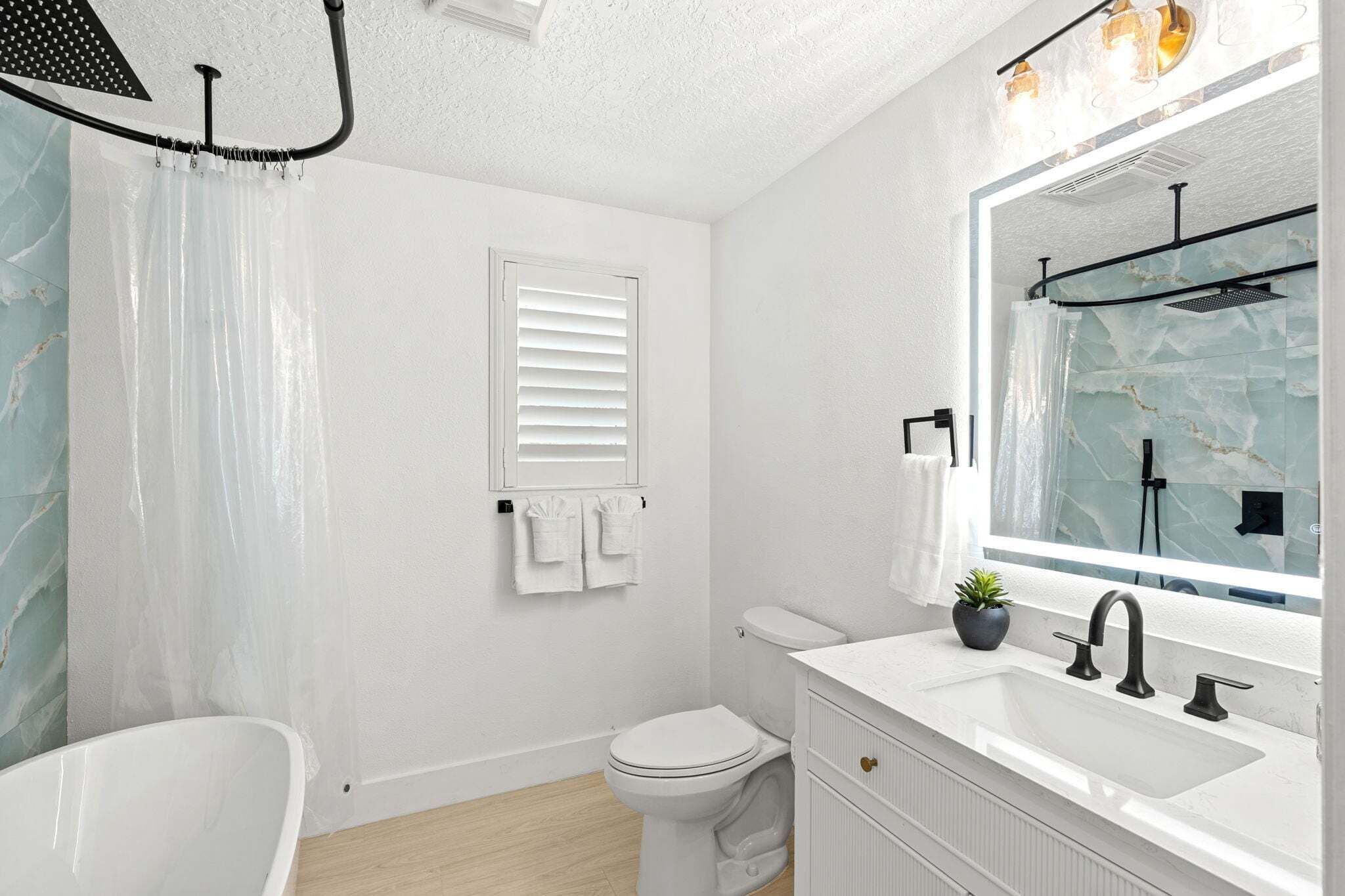 A bathroom with a bathtub, toilet, and sink.