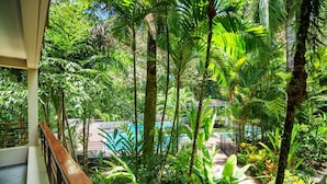 A lush indoor garden with a pool, surrounded by various tropical plants and trees. - Luxury Beachfront Resort & Jungle Wildlife (Quebrada)