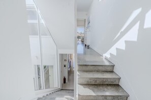 A modern interior with a staircase, glass doors, and a fire extinguisher. - Terras Novas Village Paradise By BeCherish (Albufeira)
