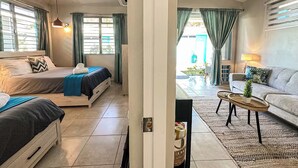 Ein Zimmer mit Bett, Sofa, Deckenventilator und Blick ins Freie.