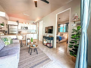 Een moderne woonruimte met keuken, eethoek en slaapkamer.