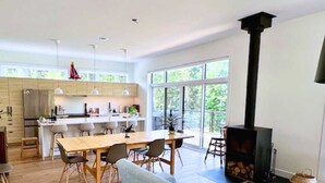 Une cuisine moderne avec un coin repas, un canapé et une cheminée.