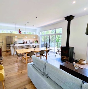 Una cocina moderna con comedor, sofá y chimenea.