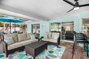 A spacious living area with a sofa set, a coffee table, and a ceiling fan. - Mermaid Cove | Backyard Dream: Putting Green, Pool (Siesta Key)