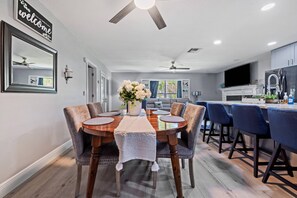 Una cocina moderna con comedor, ventilador de techo y un letrero de bienvenida.