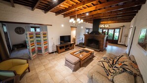A living room with a fireplace, a television, and a sofa. - La Soleada Polo Ranch (Mercedes)