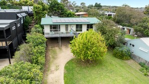 A residential property with a green-roofed house, a visible deck, and a surrounding garden. - Velora Rye Pet Friendly Home (Rye)