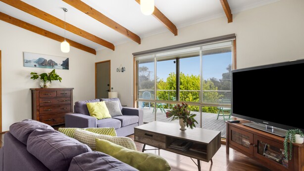 A modern living room with a large flat-screen TV, a sofa, a coffee table, and a wooden cabinet. - Velora Rye Pet Friendly Home (Rye)