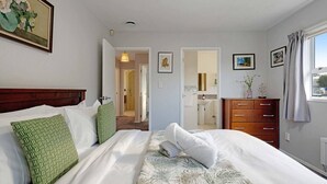 A hotel room with a bed, a dresser, a mirror, and a window. - Remuera 3BR Elegance Home with Outdoor Living (Auckland Central Suburbs)