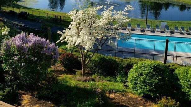 Ein Golfplatz mit Teich, Schwimmbad und Bergblick.