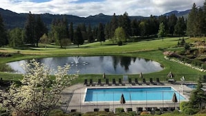 Ein Pool mit Blick auf einen Golfplatz und Berge im Hintergrund.