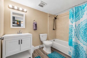 A bathroom with a vanity, toilet, shower, and a mirror with lights. - Travel Nurse 1BR · 3 mi SSM SLU · Pet-Friendly · Long Stays (St. Louis)