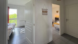 Une chambre d’hôtel avec un lit, une table de chevet, un luminaire suspendu et une vue sur la verdure.