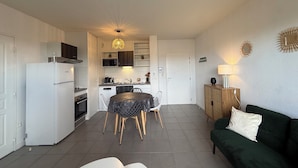 Une cuisine moderne avec un coin repas, un canapé et une lampe.