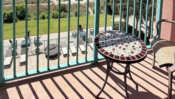 Ein Balkon mit Meerblick, einem Tisch, Stühlen und einem Geländer.