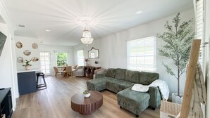 A spacious living area with a large sectional sofa, a round coffee table, and a dining area with chairs and a table. - 3 bedroom & 2 bathroom home in Glendora, CA with a pool and spa/hot tub (Glendora)