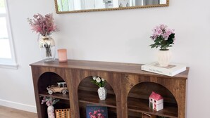 A wooden console table with shelves, a mirror, and various decorative items. - 3 bedroom & 2 bathroom home in Glendora, CA with a pool and spa/hot tub (Glendora)