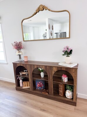 Une console en bois dotée d’étagères, d’un miroir et de divers objets décoratifs.