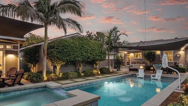A swimming pool with lounge chairs, a covered seating area, and a house with a landscaped garden. - 3 bedroom & 2 bathroom home in Glendora, CA with a pool and spa/hot tub (Glendora)