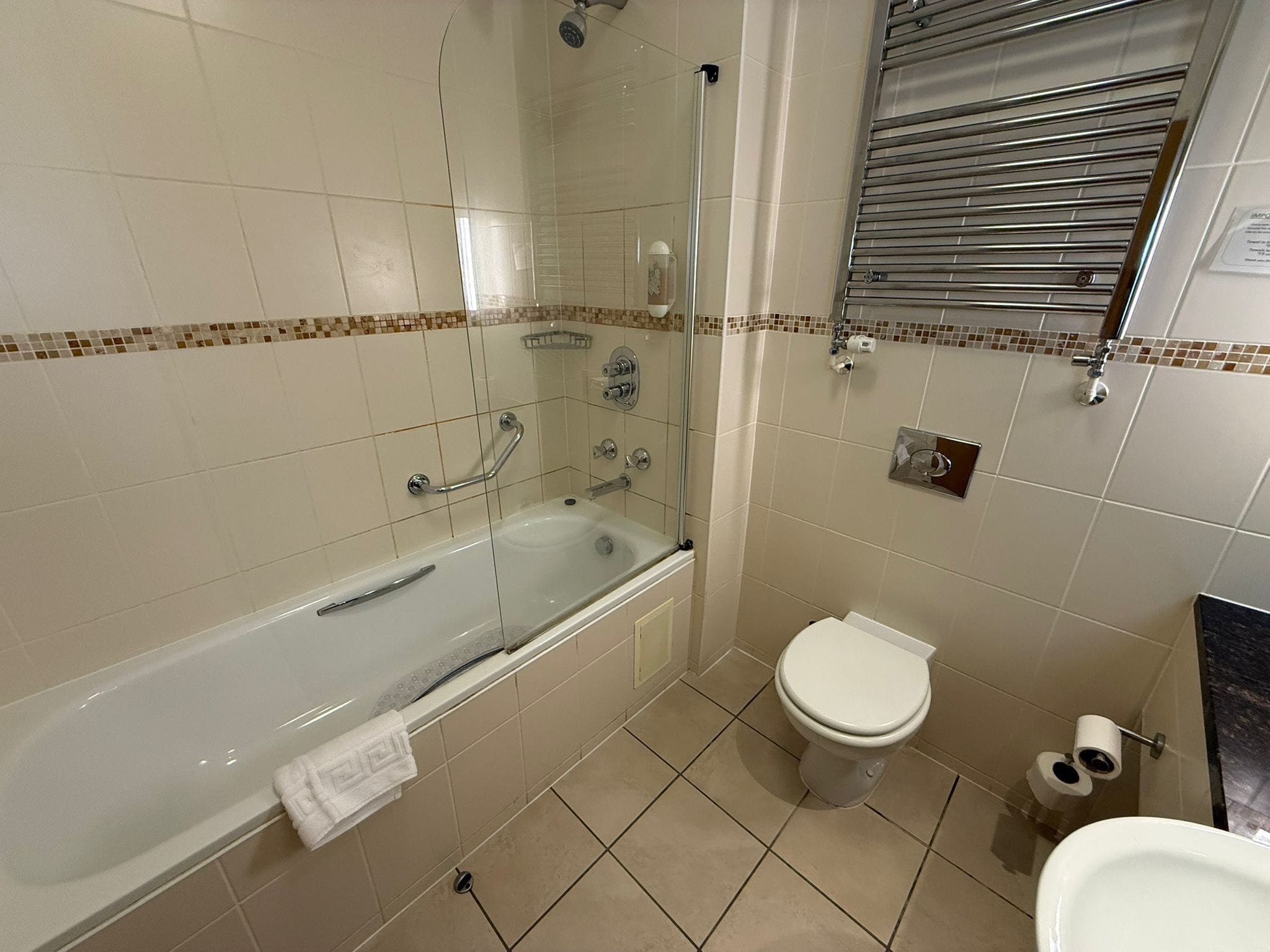A bathroom with a bathtub, toilet, and shower.