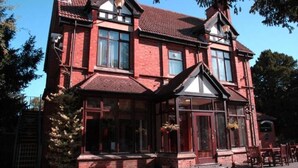 A two-story building with large windows, a brick facade, and a traditional architectural style.
