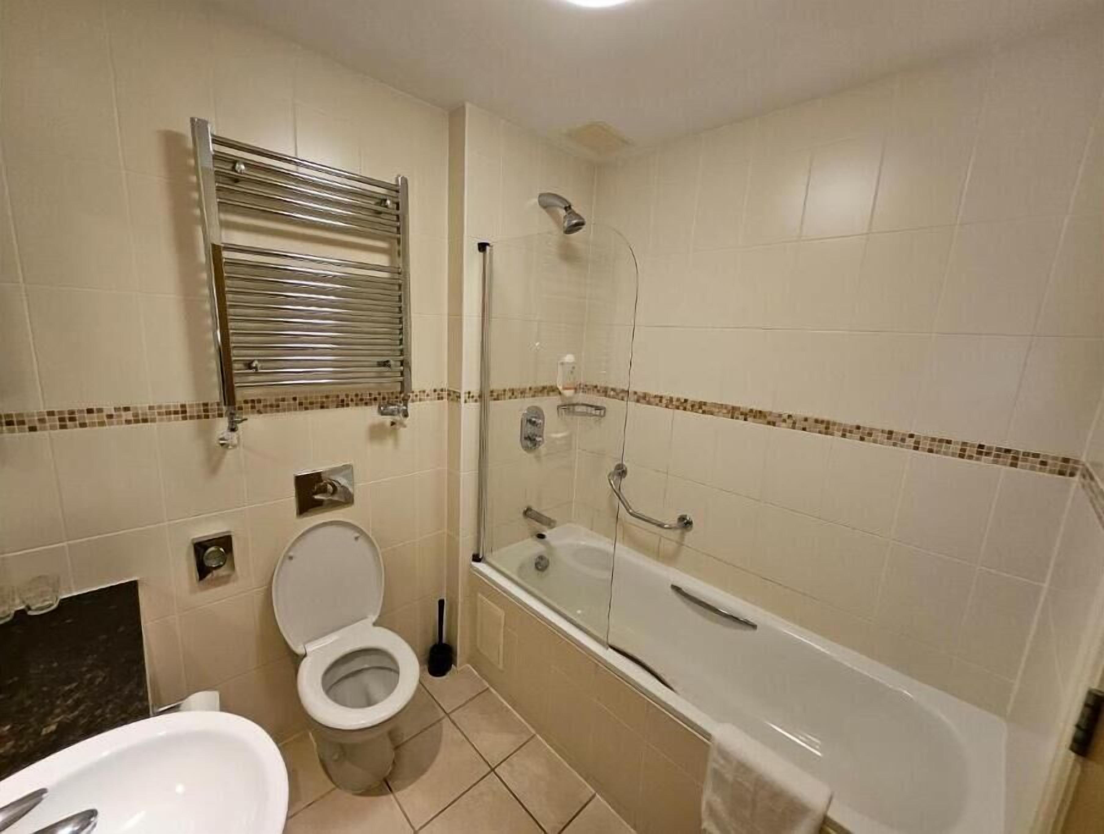 A bathroom with a toilet, a shower, and a bathtub.