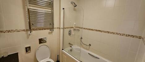 A bathroom with a toilet, a shower, and a bathtub.