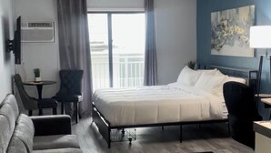 Ein Hotelzimmer mit einem Bett, einer Couch, einem kleinen Tisch und einem Sessel.