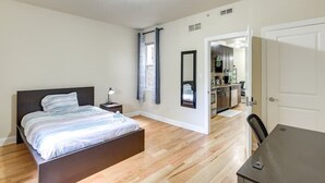 A bedroom with a bed, bedside table, and a view into the kitchen. - Spacious 5-bedroom apartment in lovely Philadelphia with WiFi, Free Parking (Philadelphia)