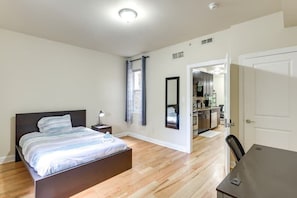 A bedroom with a bed, bedside table, and a view into the kitchen. - Spacious 5-bedroom apartment in lovely Philadelphia with WiFi, Free Parking (Philadelphia)