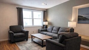 Ein Wohnzimmer mit einer Sofagarnitur, einem Couchtisch und zwei Stehlampen.