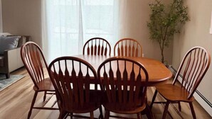 Un coin repas avec une table et des chaises en bois, un canapé et une plante.