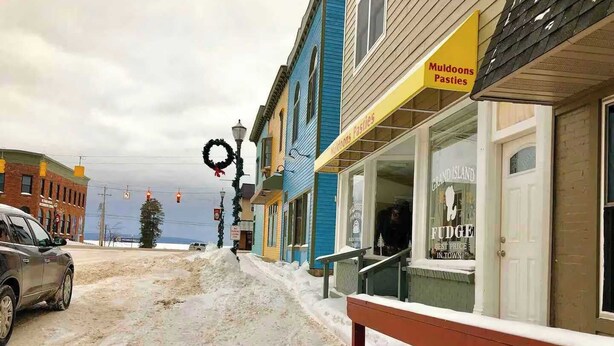 A building with a sign for 'Muldockons Pastries' and a 'Grand Island Fudge' shop.